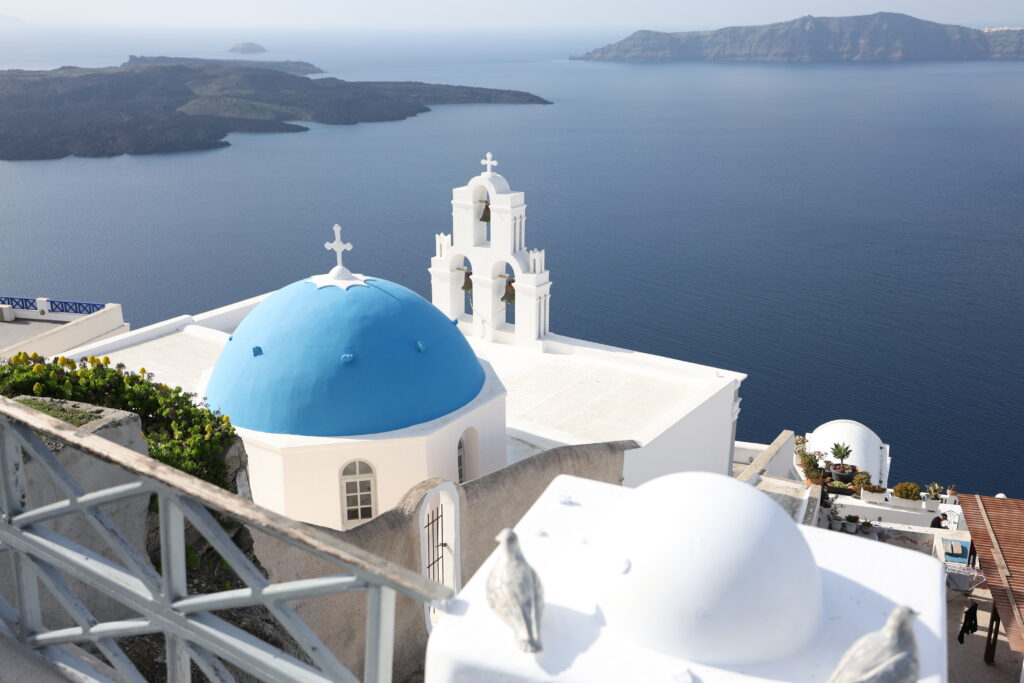 Firostefani a blue dome church with backround of volcano