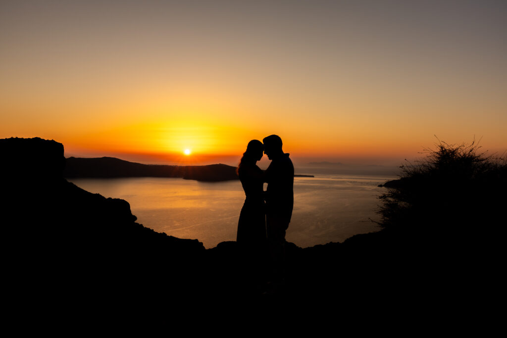 couple photography in Santorini with sunset background and caldera cliff